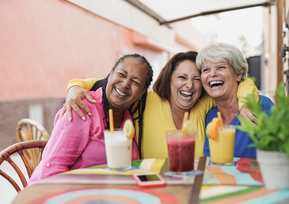 A group of women smiling at a table with drinks