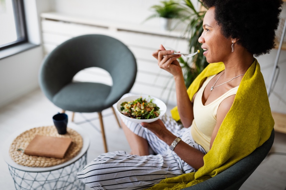 A person eating a bowl of salad