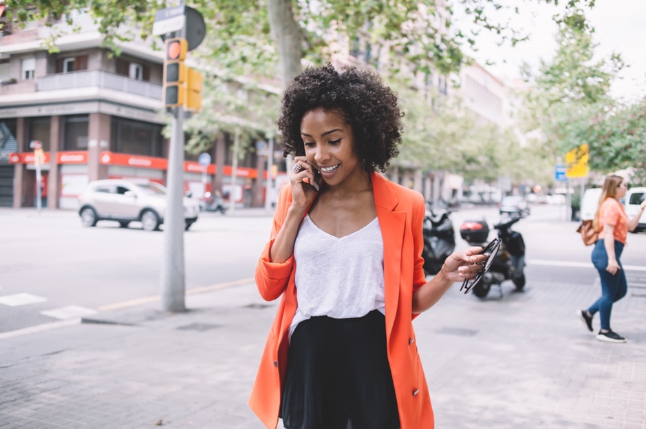 A person in an orange jacket talking on a cell phone