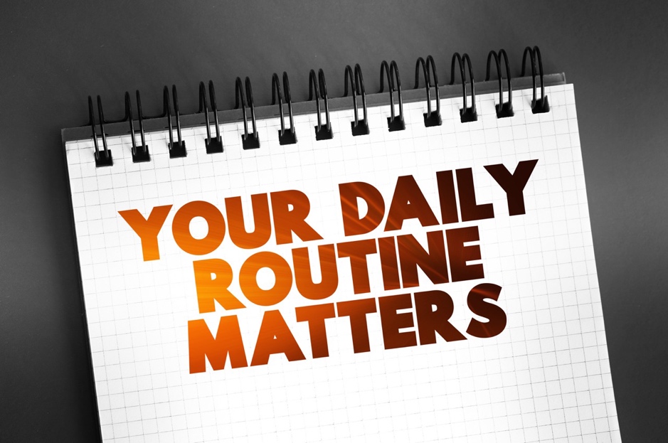 A spiral notebook with text on it saying your daily routine matters.
