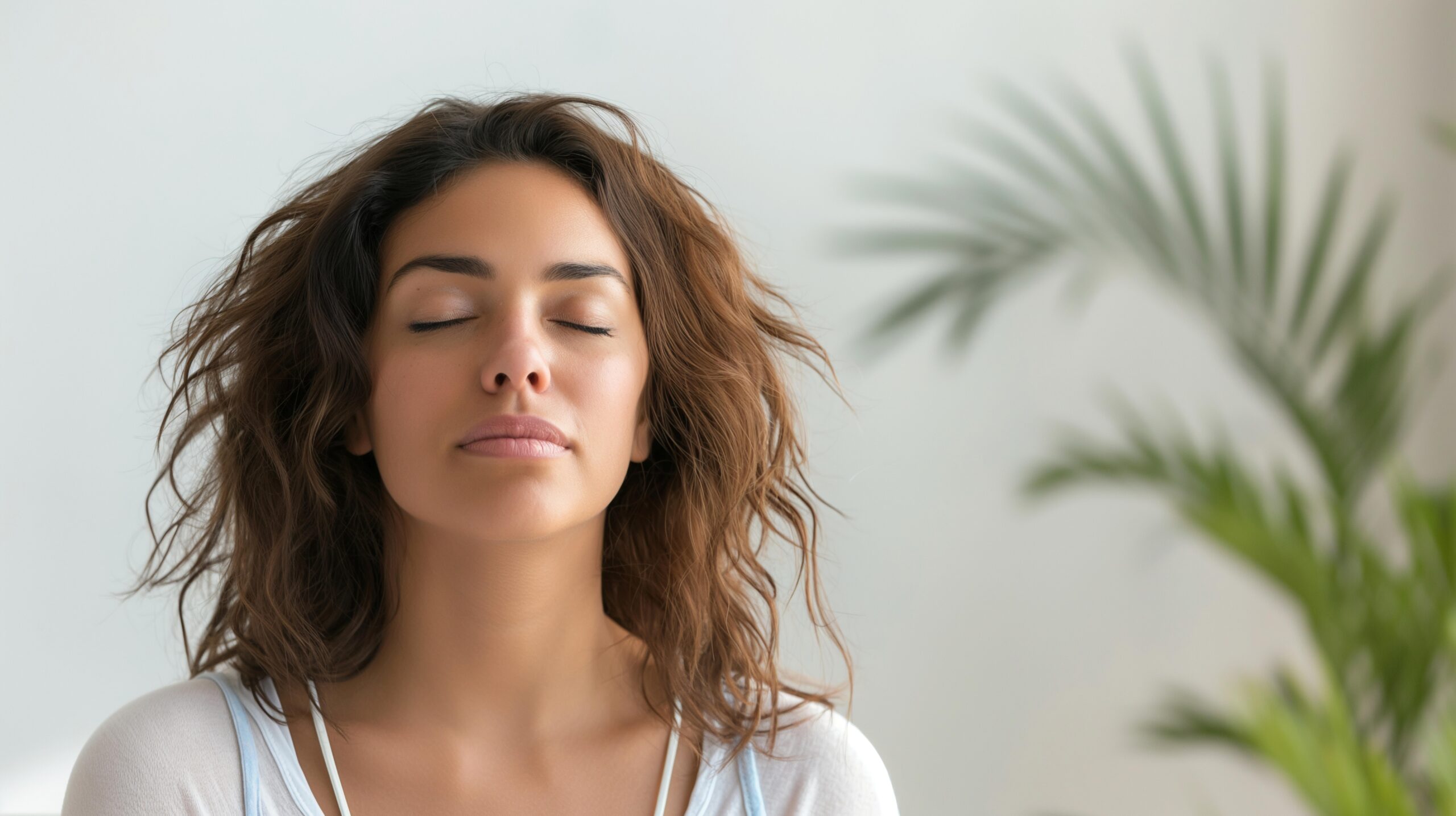 A person with her eyes closed deep breathing. 