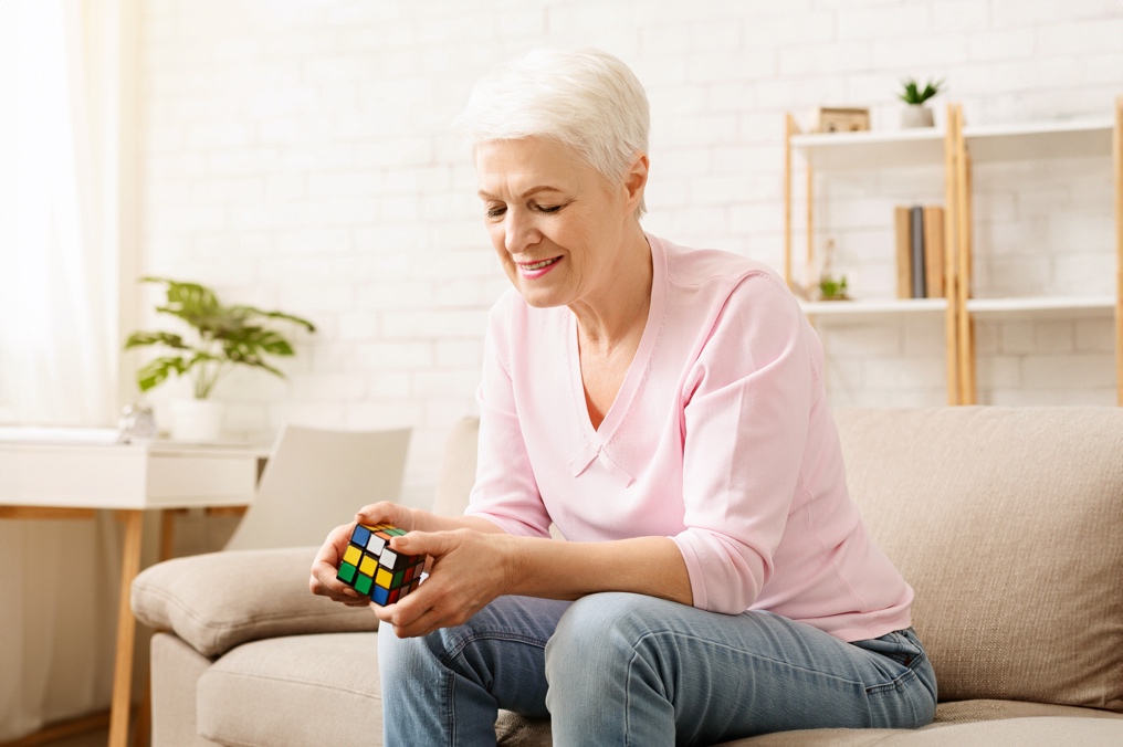 A woman sitting on a couch holding a rubik's cube